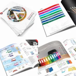 Katalogi artykułów biurowych różnych firm, otwarte na stronach prezentujących segregatory, akcesoria biurowe i artykuły piśmiennicze, ułożone na białym tle.