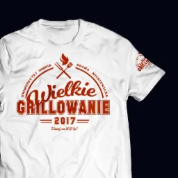 Biała koszulka z czerwonym nadrukiem 'Wielkie Grillowanie 2017 Uniwersytet im. Adama Mickiewicza', widoczny motyw płomienia i widelec do grilla.