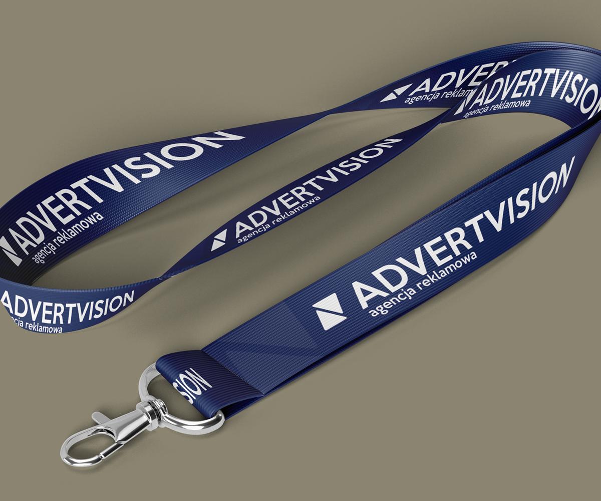 Niebieskie smycze reklamowe z logo 'ADVERTVISION' i napisem 'agencja reklamowa' na szarym tle, widoczne zapięcie smyczy.