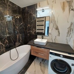 NOVEX Sławomir Nowak - Nowoczesna łazienka z wanną wolnostojącą, umywalką nablatową, pralką Samsung i marmurowymi płytkami na ścianach i podłodze.