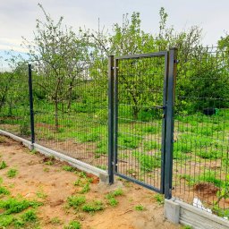 REY-KOP Miłosz Baleja - Nowo zamontowane ogrodzenie panelowe z furtką, osadzone na betonowej podmurówce, widoczne drzewa owocowe w tle.