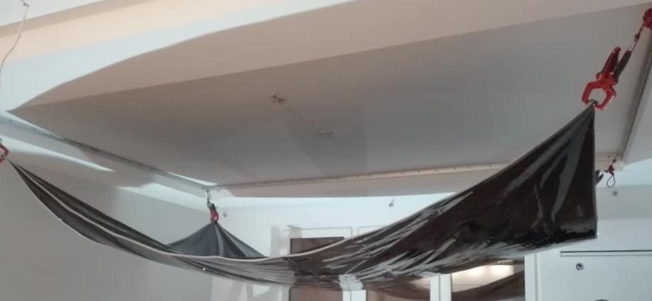 Folia ochronna podwieszona do sufitu za pomocą zacisków malarskich, zabezpieczenie przed zabrudzeniem podczas prac remontowych.