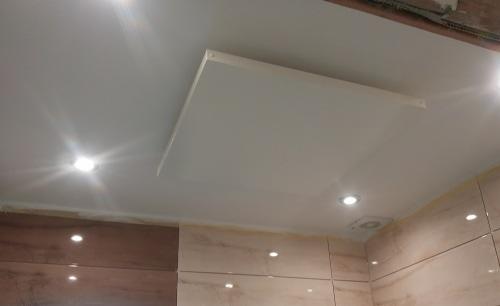 Panel grzewczy sufitowy zamontowany w kuchni, widoczne oświetlenie punktowe i fragment instalacji elektrycznej.