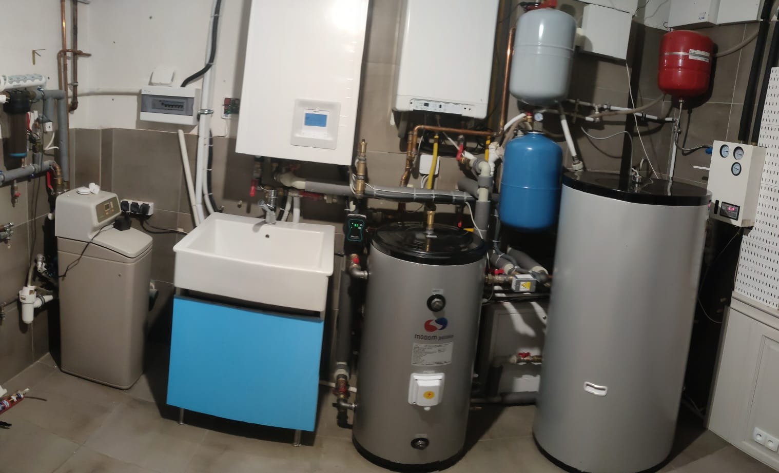 Kompleksowa instalacja grzewcza w kotłowni z pompą ciepła, kotłem gazowym, solarami, zbiornikami buforowymi, zmiękczaczem wody i armaturą hydrauliczną.