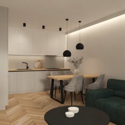 JTG Design - Nowoczesne wnętrze: parkiet w jodełkę, minimalistyczna kuchnia z drewnianym blatem, okrągły stolik kawowy i lampy w kształcie pierścieni. Stonowana kolorystyka.