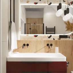 JTG Design - Nowoczesna łazienka z umywalką nablatową, podświetlanym lustrem w mozaikowej ramie i drewnianymi panelami. Minimalistyczne czarne baterie i akcenty kolorystyczne.