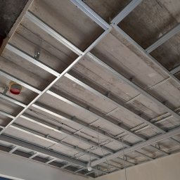 New Home, Kompleksowe Wykończenia Wnętrz - Metalowa konstrukcja sufitu podwieszanego z widocznymi przewodami elektrycznymi przed montażem płyt karton-gips