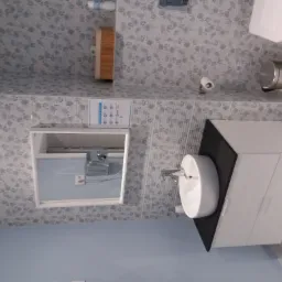 Nowoczesna łazienka z umywalką na szafce w kolorze bieli i czerni, toaleta, kosz na śmieci, lustro z zamontowanym dozownikiem mydła i płytki w subtelny wzór kwiatowy.