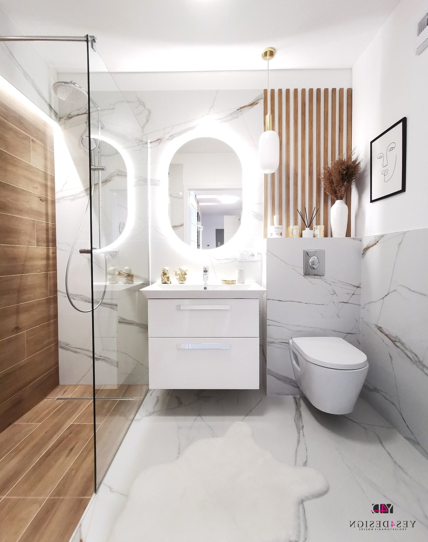 Nowoczesna łazienka z marmurowymi płytkami, owalnym lustrem z podświetleniem LED, kabiną prysznicową ze szklaną ścianką i drewnianymi akcentami dekoracyjnymi.