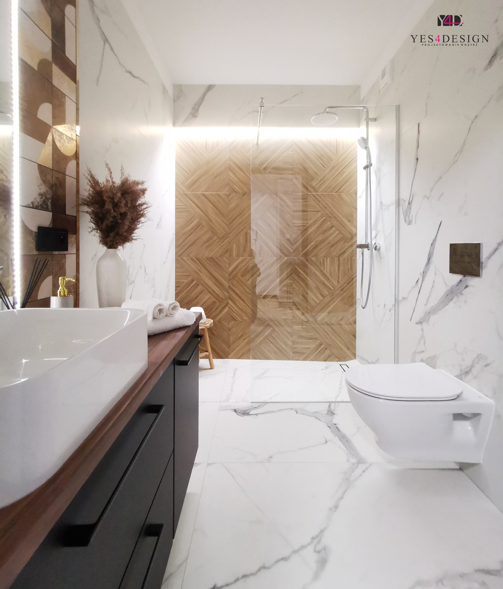 Nowoczesna łazienka z marmurowymi płytkami, drewnianą mozaiką w kabinie prysznicowej, wiszącą toaletą i umywalką nablatową na czarnej szafce z drewnianym blatem.