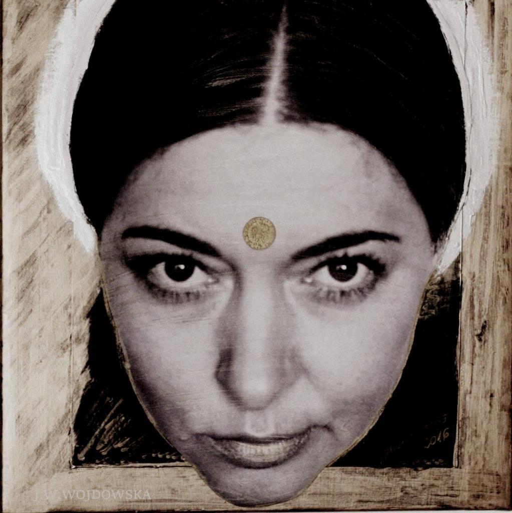 Portret kobiety z monetą na czole, w sepii, na tle drewnianej ramy z białymi akcentami. Nietypowy kadr z góry, skupiony na wyrazistych oczach i detalu monety.