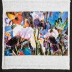 Biała, kwadratowa serwetka z nadrukiem przedstawiającym bukiet irysów i innych kwiatów w stylu akwareli, ułożona na czarnym tle.