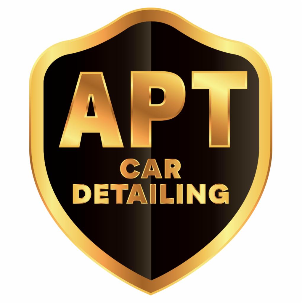 Logo firmy APT Car Detailing w kształcie czarno-złotej tarczy.
