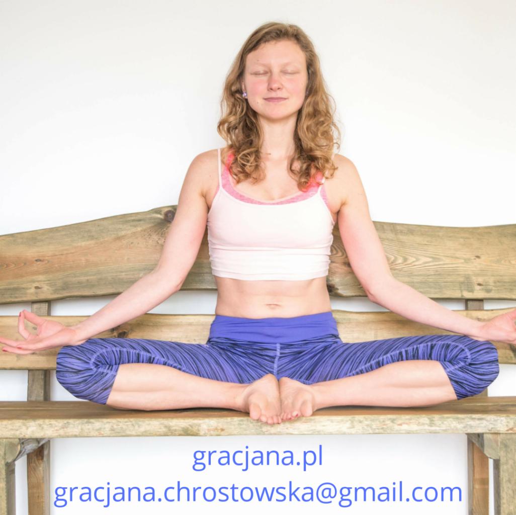 Kobieta w pozycji Baddha Konasana na drewnianej ławce, z zamkniętymi oczami i dłońmi w mudrze, na tle białej ściany, z widocznym adresem strony internetowej i adresem email na dole zdjęcia.