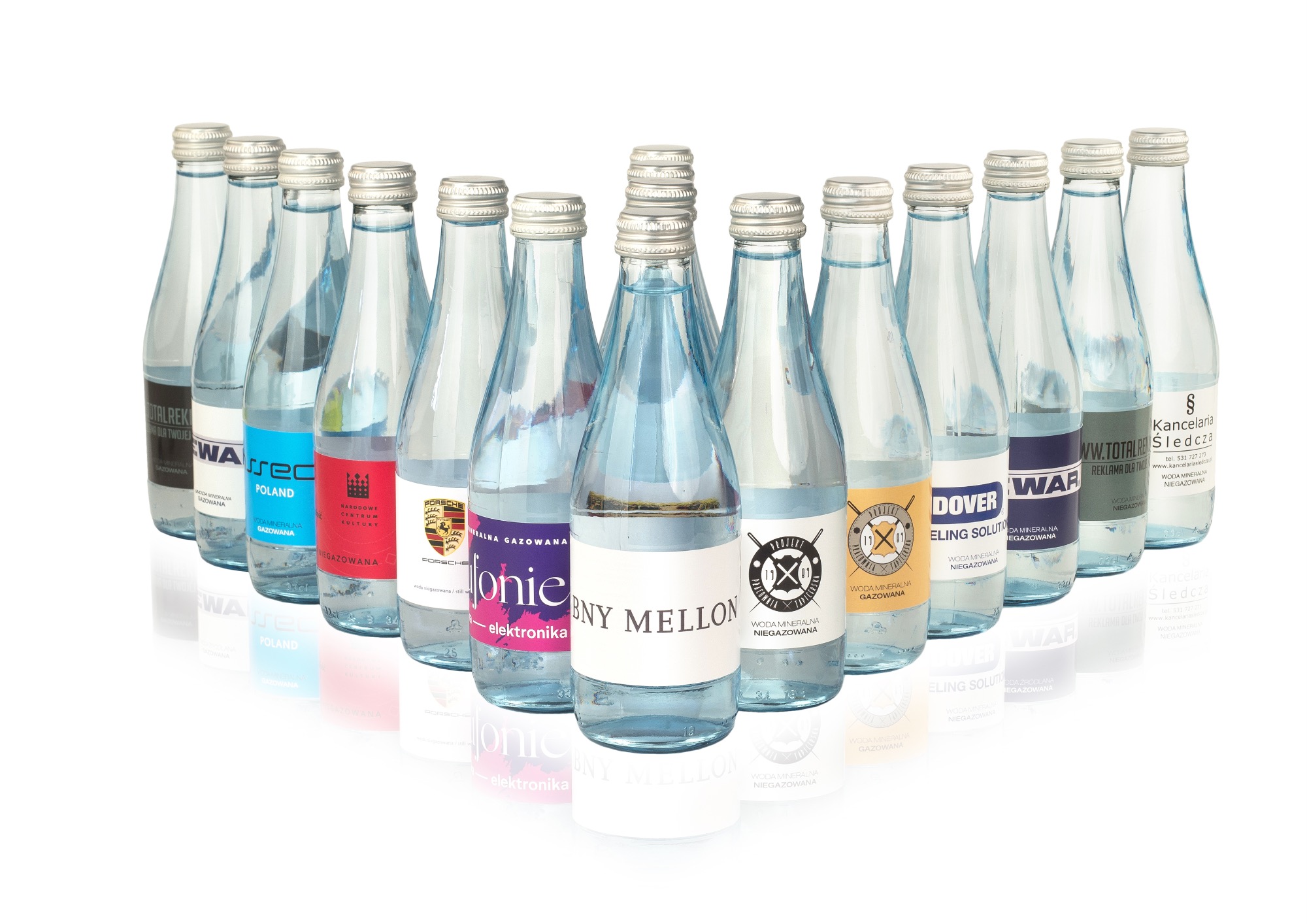 Rząd butelek wody mineralnej z różnymi etykietami, prezentacja identyfikacji wizualnej marek, białe tło.