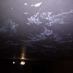 S.S.bud - Ciemny sufit z dekoracyjną, nieregularną fakturą przypominającą chmury, oświetlony przez dwa halogenowe reflektory.