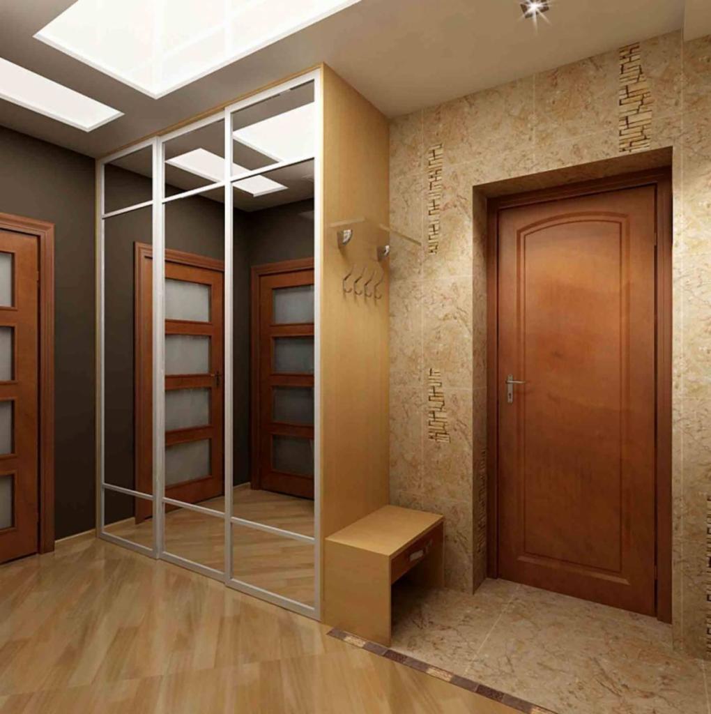 Nowoczesny przedpokój z lustrzaną szafą przesuwną, wbudowaną ławką z wieszakami i marmurową ścianą z dekoracyjnym motywem, oświetlony sufitowymi panelami LED.