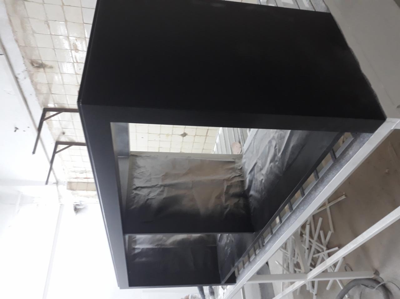 Metalowa konstrukcja mebla w trakcie renowacji, zabezpieczona folią, widoczne ślady farby w sprayu.