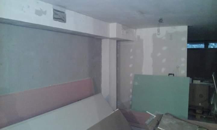 Wnętrze w trakcie remontu, widoczne płyty kartonowo-gipsowe, surowy tynk na ścianach, niedokończone obramowanie drzwi.