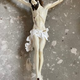 Natalia Kowalczuk Art - DA VINTAGE SPÓŁKA Z OGRANICZONĄ ODPOWIEDZIALNOŚCIĄ - Polichromowana figura Jezusa Chrystusa Ukrzyżowanego na tle surowej, szarej ściany z widocznymi śladami napraw i niedoskonałości.