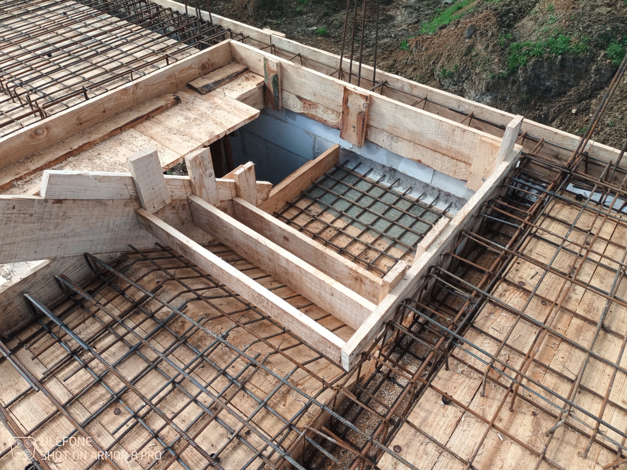 Zbrojenie i szalunek pod wylewkę fundamentową z widocznym otworem, przygotowane do zalania betonem.