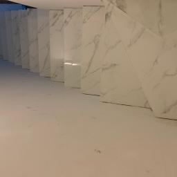 Nonamee - Wykończona łazienka ze ścianami i podłogą wyłożonymi białymi płytkami imitującymi marmur, widok z dołu na wnękę.