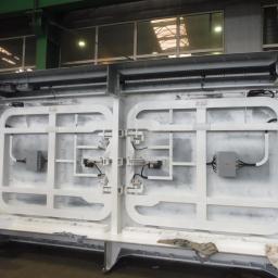 Vogen sp. z o.o. - Biała, pomalowana konstrukcja metalowa z elementami automatyki i przewodami, prawdopodobnie część większej maszyny lub urządzenia przemysłowego, widoczna w hali produkcyjnej.