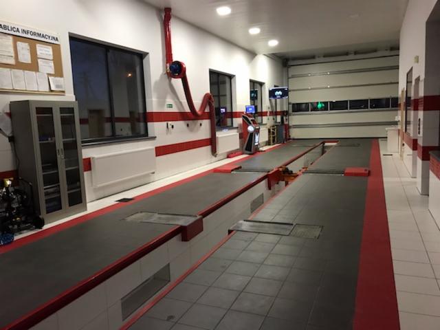 Wnętrze stacji kontroli pojazdów z kanałami rewizyjnymi, wyposażeniem diagnostycznym i wentylacją stanowisk pracy.