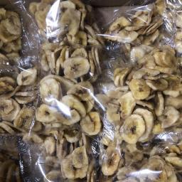 SM ARGO Dorota Skuza - Karton wypełniony przezroczystymi torebkami z suszonymi plasterkami bananów, widoczne detale tekstury owoców i zgrzew torebki.