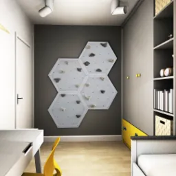 Pokój dziecięcy z biurkiem, łóżkiem i ścianką wspinaczkową z sześciokątnych paneli, oświetlony punktowo, z dekoracjami ściennymi i półkami.