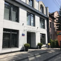 Elewacja budynku Centrum Szkoleniowego CSL Lektor z tablicą informacyjną, zaparkowany motocykl przed wejściem.