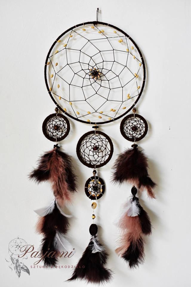 Ręcznie robiony łapacz snów z brązowymi piórami i beżowymi koralikami na białym tle, widoczne logo wykonawcy w lewym dolnym rogu.