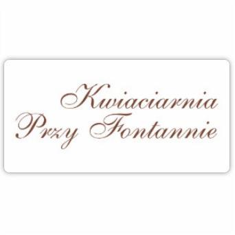 Szyld kwiaciarni z brązowym, ozdobnym napisem 'Kwiaciarnia Przy Fontannie' na białym tle.