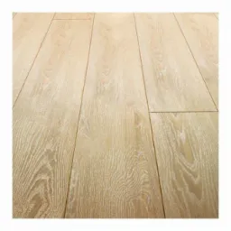 Jasne panele podłogowe z wyraźnym usłojeniem, ułożone wzdłuż pomieszczenia, z delikatnym połyskiem. Widoczna szczelina między panelami.