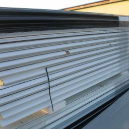 F.H.U - Stos płyt warstwowych z rdzeniem piankowym, zabezpieczonych folią i spiętych czarnym sznurkiem, widoczne od strony krawędzi i powierzchni.