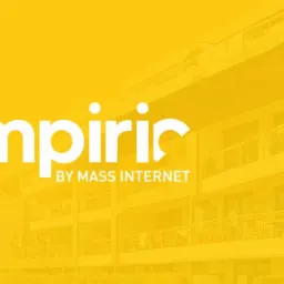 Żółte tło z białym napisem 'empiric by MASS INTERNET' na tle budynku mieszkalnego.