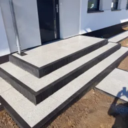 Wejście do domu z zastosowaniem obrzeży palisadowyvh w połączeniu z płytą preston