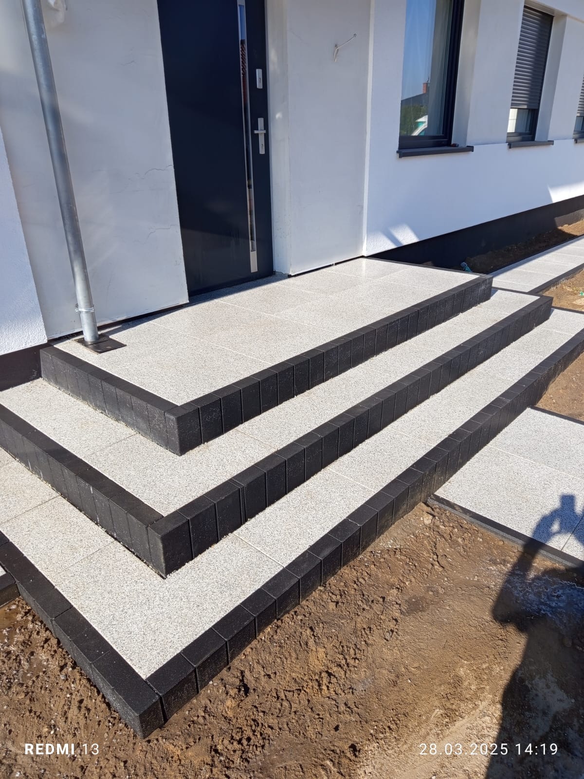 Wejście do domu z zastosowaniem obrzeży palisadowyvh w połączeniu z płytą preston