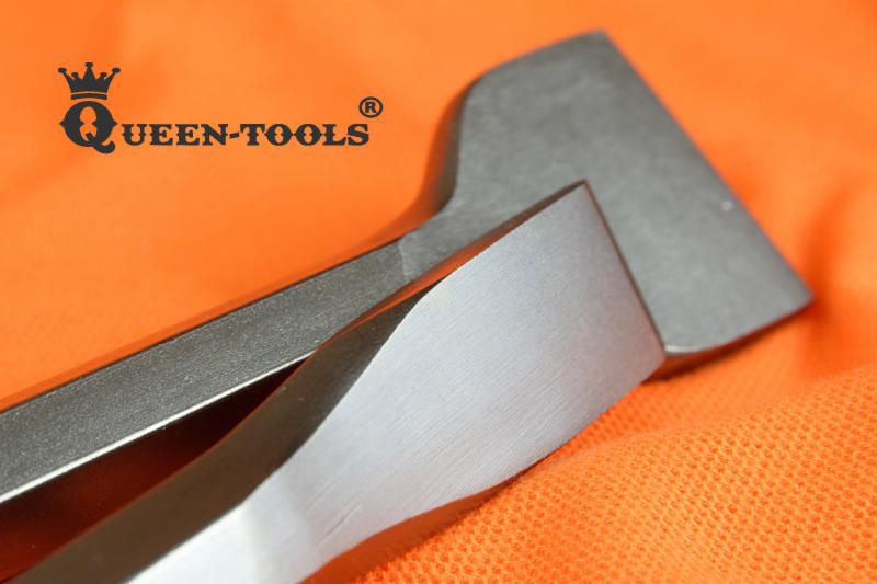 Dwa dłuta murarskie, jedno z logo 'QUEEN-TOOLS', leżą na pomarańczowej tkaninie.