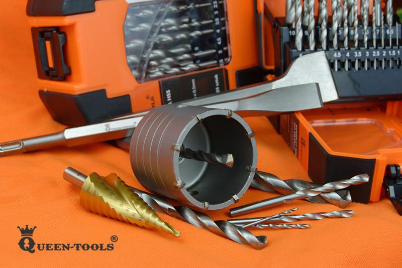 Zestaw wierteł różnego typu i rozmiaru, w tym wiertło koronowe, wiertło stożkowe, oraz wiertła spiralne, ułożone na pomarańczowym tle wraz z pudełkiem na wiertła.