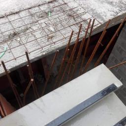 P.W.KOWAL Daniel Kowalski - Zbrojenie fundamentu z wystającymi prętami stalowymi, widoczna siatka zbrojeniowa i betonowy szalunek na krawędzi wykopu.