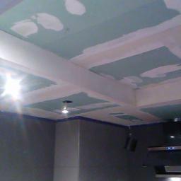 Renova Remonty i Wykończenia Wnętrz - Kuchenny sufit z płyt kartonowo-gipsowych w trakcie szpachlowania, widoczne łączenia płyt i wstępne warstwy gładzi, zarys instalacji oświetleniowej.