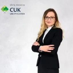 Portret kobiety w okularach i czarnym garniturze, z założonymi rękami na tle logo firmy CUK Ubezpieczenia.