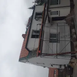 Dom jednorodzinny w trakcie wymiany pokrycia dachowego, widoczne rusztowania i elementy konstrukcji dachu.