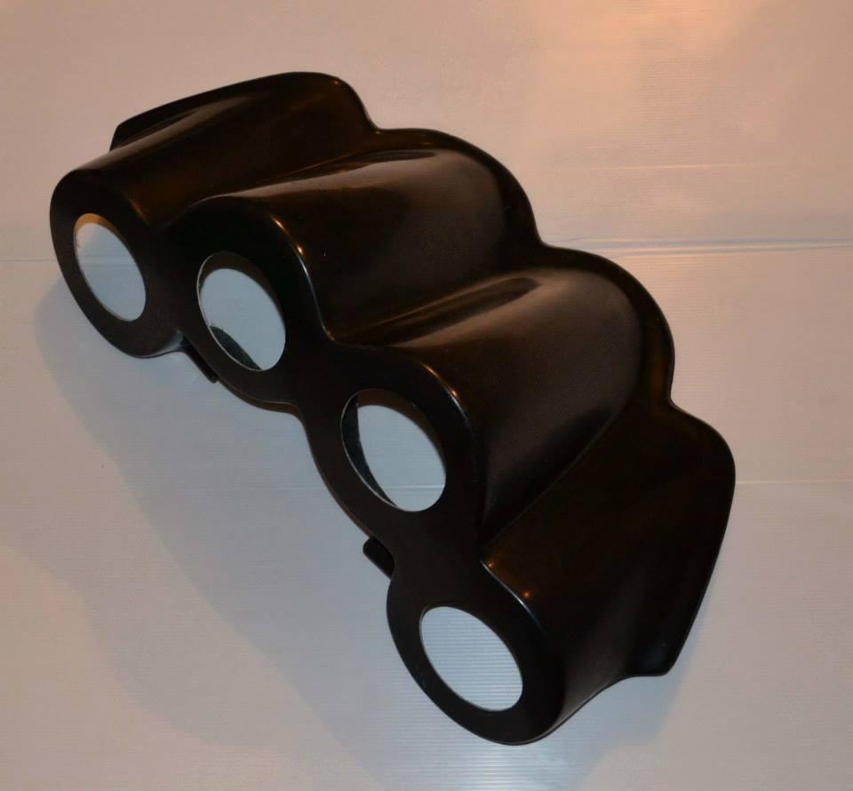 Czarny, błyszczący element konstrukcyjny z trzema okrągłymi otworami, prawdopodobnie fragment obudowy lub filtr do basenu, leżący na białym tle.