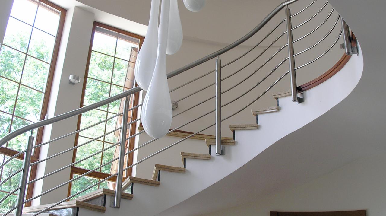 Bieg schodów z jasnymi stopniami i nowoczesną balustradą ze stali nierdzewnej, z giętymi poprzeczkami, oświetlony naturalnym światłem z dużego okna, z dekoracyjnymi lampami w kształcie kropli.