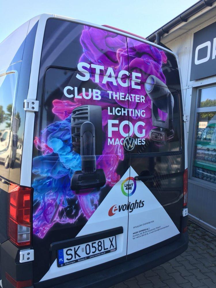 Tylna część oklejonego busa marki Volkswagen z grafiką przedstawiającą sprzęt oświetleniowy sceniczny, efekty dymne oraz napisy: STAGE, CLUB THEATER, LIGHTING, FOG MACHINES, logo firmy Evolights...
