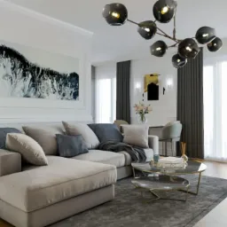 Salon w stylu nowoczesnym z narożnikiem w odcieniach beżu i szarości, okrągłym stolikiem kawowym z marmurowym blatem, abstrakcyjnym obrazem na ścianie i designerską lampą sufitową z kulistymi...