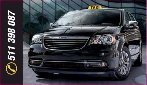 Czarny minivan z żółtym znakiem TAXI na dachu, zaparkowany na tle szklanego budynku, z numerem telefonu widocznym po lewej stronie.