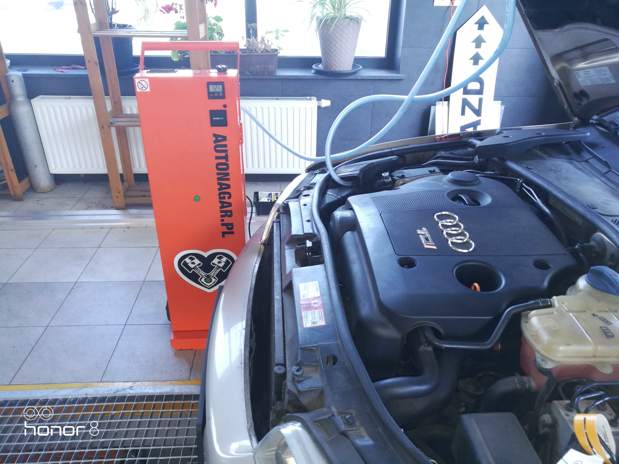 Silnik Audi z podłączonym urządzeniem do wodorowania, widoczny pomarańczowy panel z logo Autonagar.pl i schematem silnika.